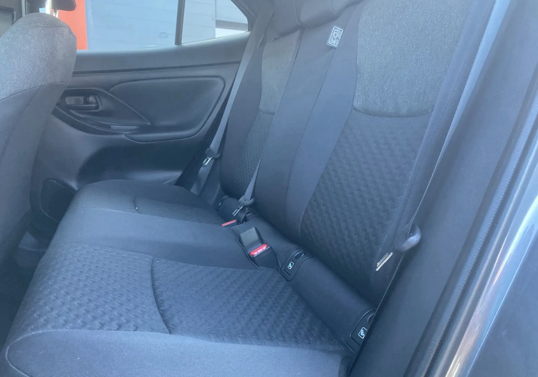 Vue côté droit de la banquette arrière tissu gris foncé de la Toyota Yaris Cross Hybride 130 Design Plus 2026.