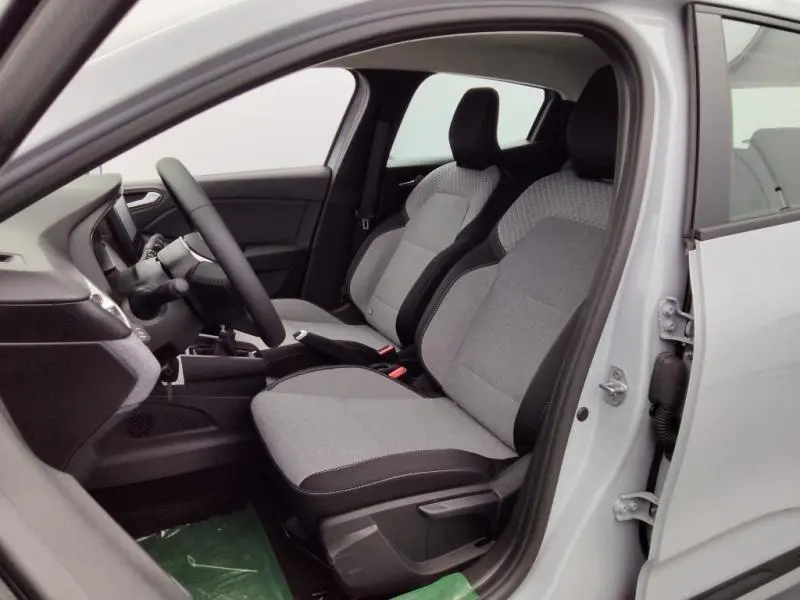 Intérieur de la Renault Clio 1.5 dCi 2025 vu côté gauche, sièges gris avec motif 3D et volant multifonction.
