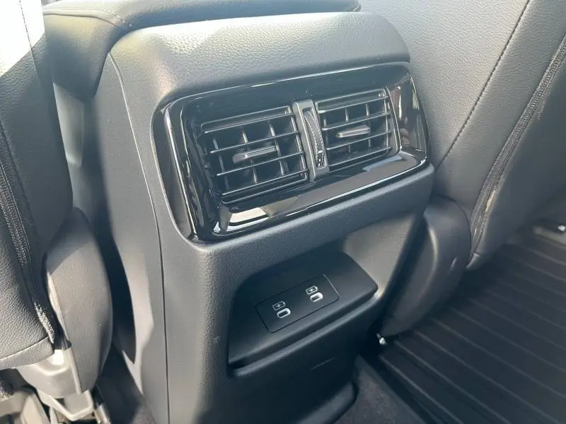 Vue rapprochée des aérateurs arrière noirs et des commandes de climatisation sur la console centrale du Honda CR-V 2024.
