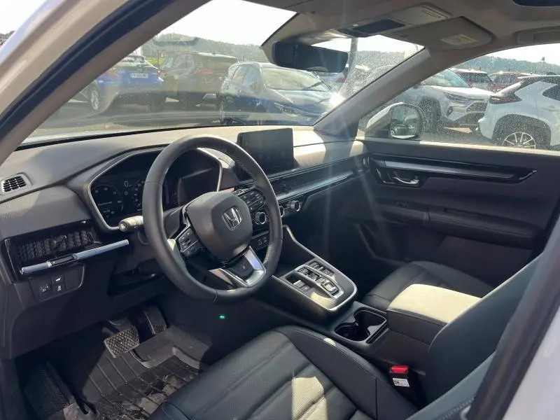 Vue intérieure côté conducteur du Honda CR-V 2024 avec tableau de bord noir et écran tactile central.