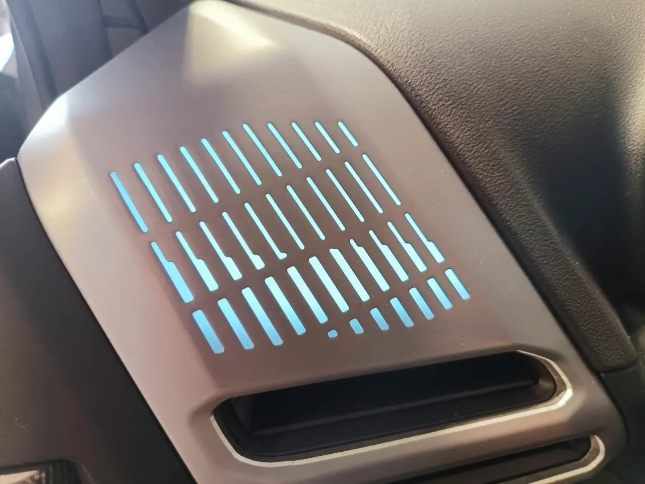 Détail de l'éclairage d'ambiance bleu sur l'insert décoratif aluminium graphite côté droit intérieur d'une BMW Série 1 gris Skyscraper.