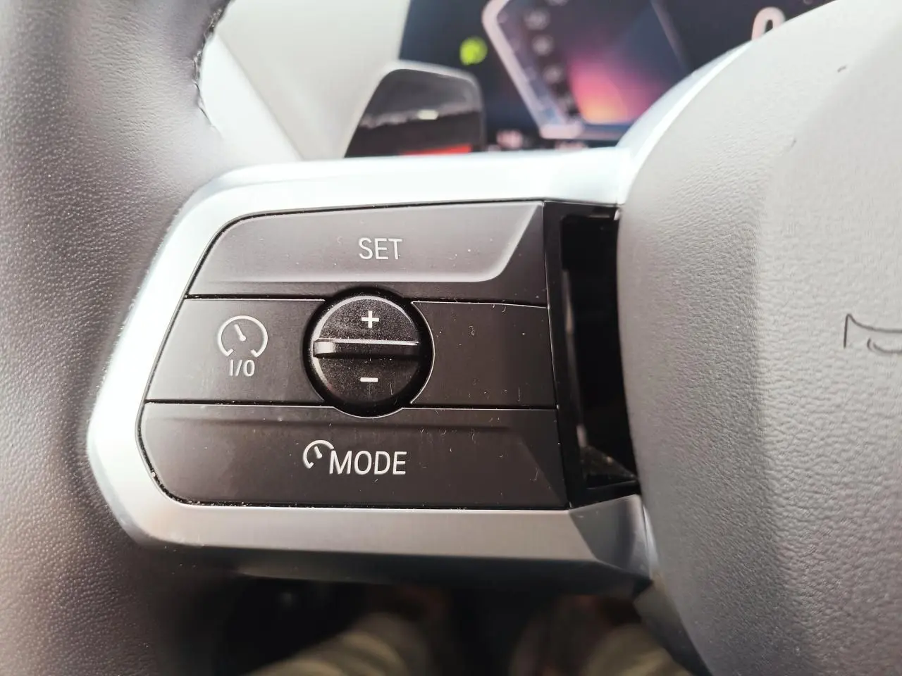 Gros plan sur les commandes de régulateur de vitesse au volant cuir noir de la BMW Série 1 2025.