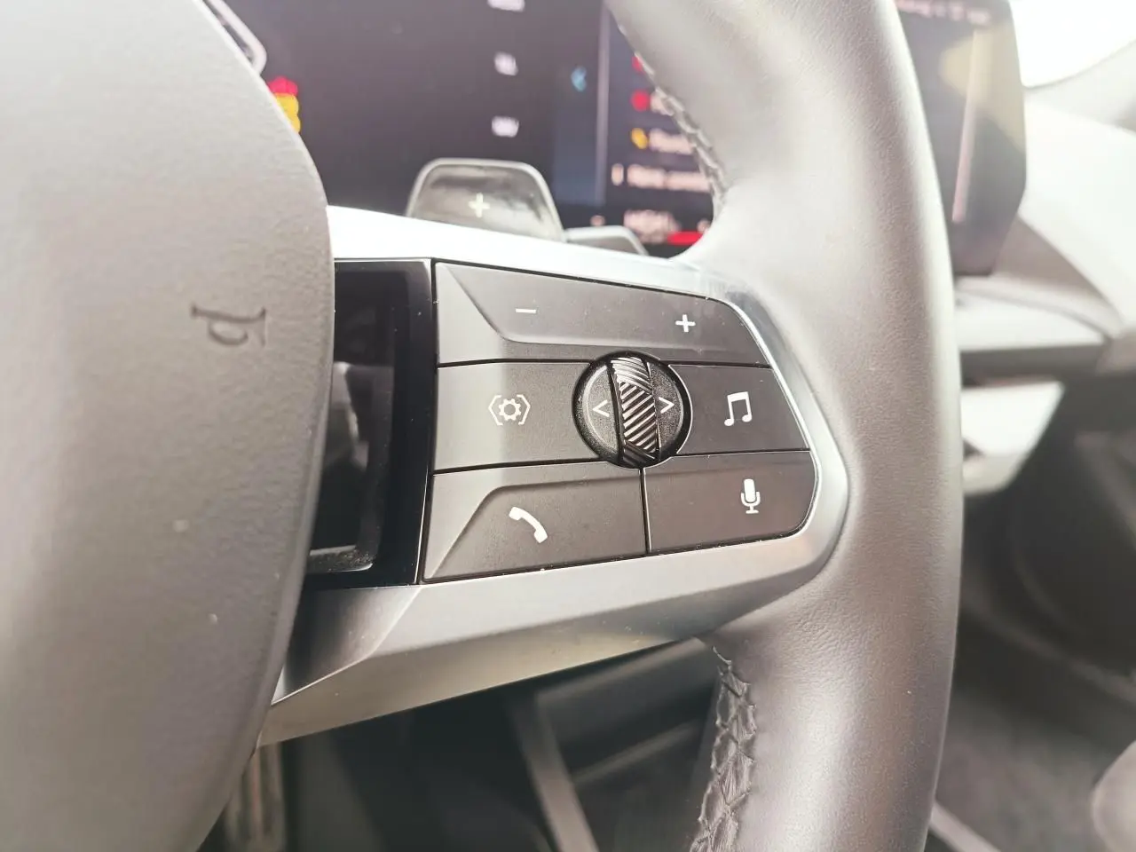 Gros plan sur les commandes multifonctions du côté droit du volant cuir de la BMW Série 1 120 M Sport 2025.