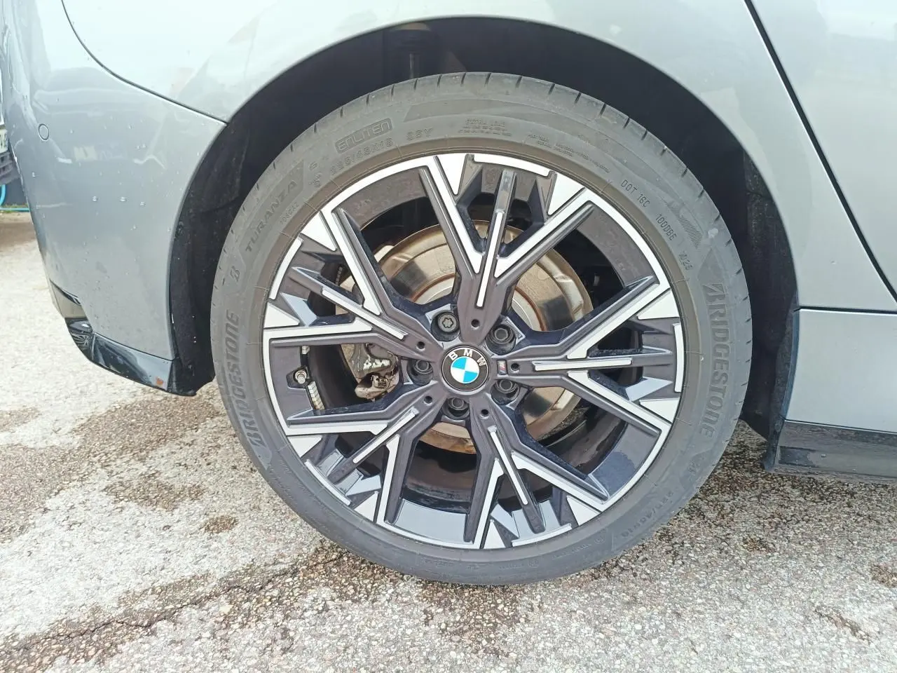 Gros plan sur la roue avant gauche de la BMW Série 1 gris Skyscraper avec jante alliage bicolore style 975 M.