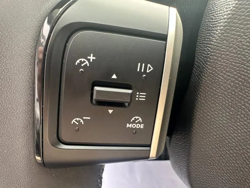 Gros plan sur les commandes au volant du Citroën C3 1.2 Turbo 100ch MAX gris Mercury, boutons de régulateur de vitesse et modes.