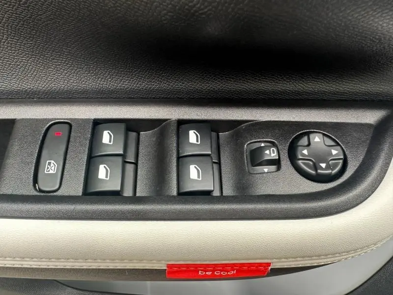 Gros plan sur les commandes des vitres et rétroviseurs côté conducteur d'une Citroën C3 1.2 Turbo 100ch MAX gris Mercury.
