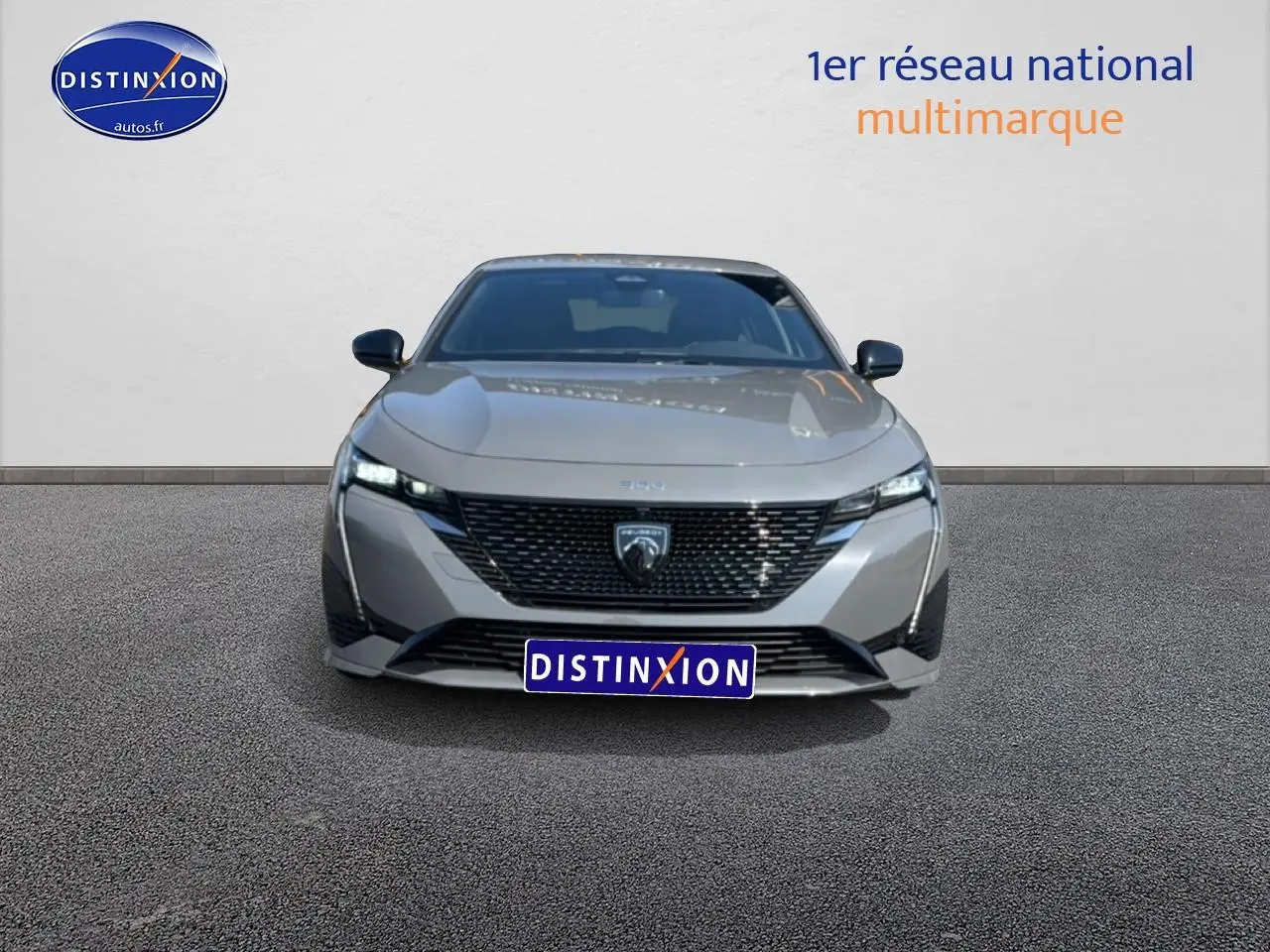 Vue avant frontale d'une Peugeot 308 gris métallisé avec calandre noire et phares LED allumés.