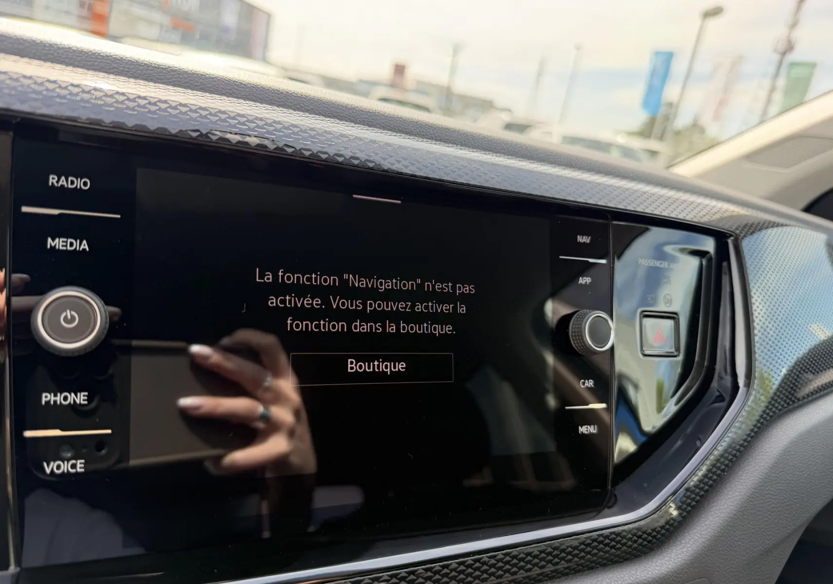 Écran tactile central du Volkswagen Taigo 2025 avec message de navigation inactive, entouré de commandes et finition noire.