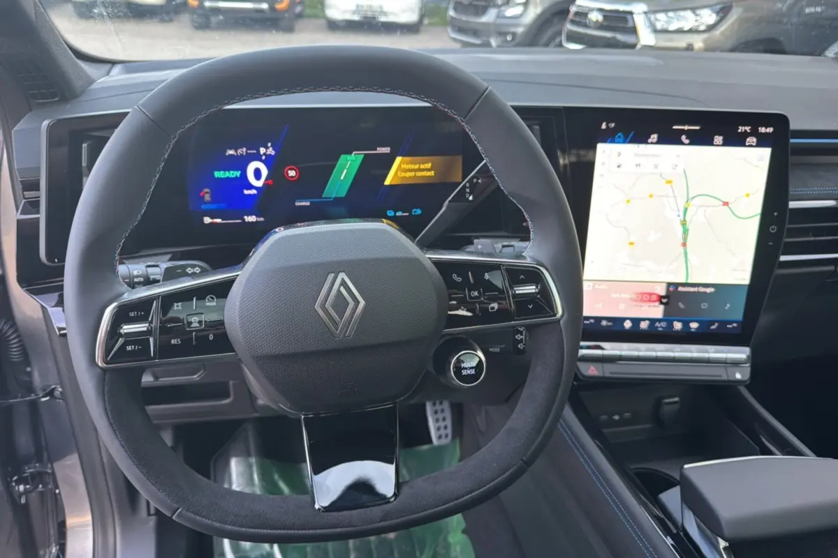 Vue intérieure centrée sur le volant cuir et l’écran tactile vertical du Renault Austral noir étoilé 2026.