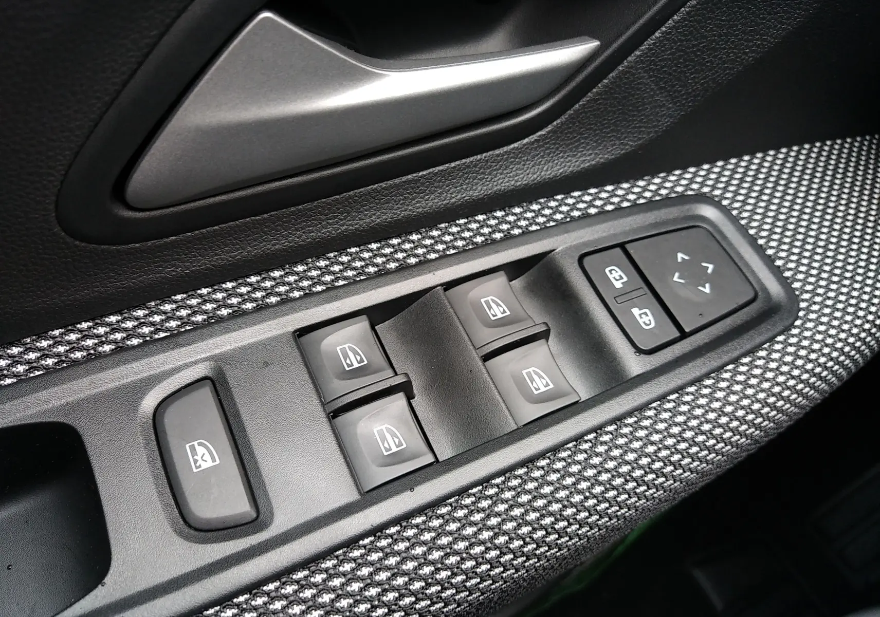 Panneau de commandes des vitres électriques côté conducteur dans l'habitacle d'une Dacia Sandero 2025 finition Expression+