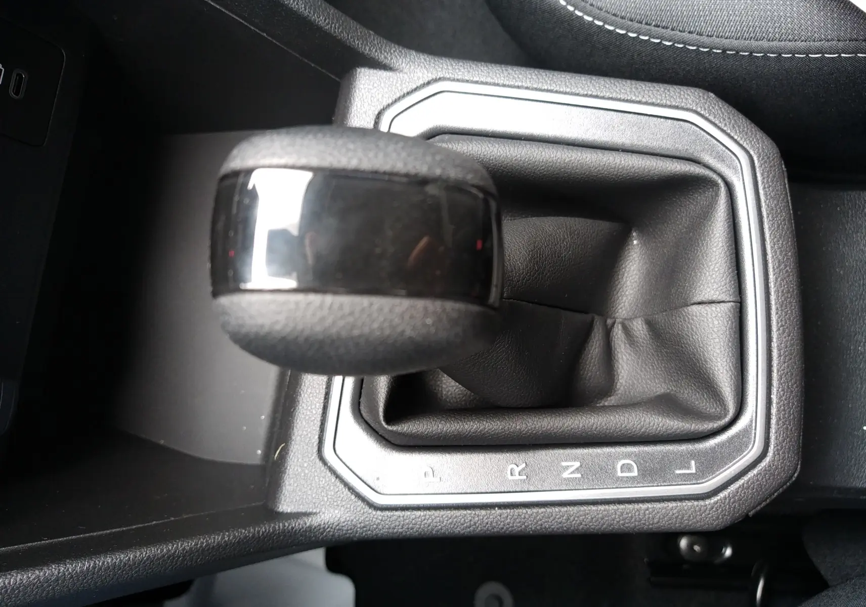 Le levier de vitesses automatique noir de la Dacia Sandero 2025, vue rapprochée sur la console centrale.