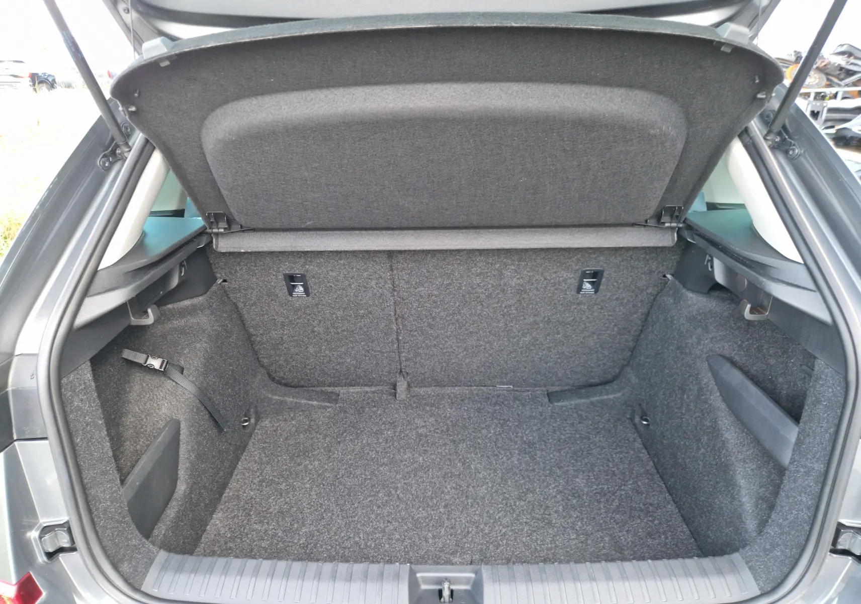 Coffre ouvert d'une Skoda Kamiq gris graphite, montrant un espace de chargement propre et bien fini.