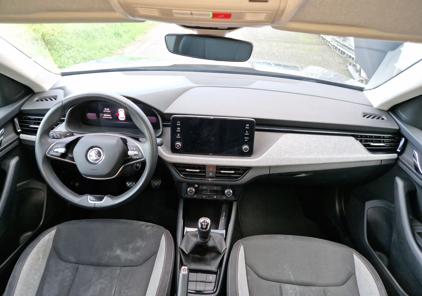 Vue intérieure frontale du Skoda Kamiq 2024 gris graphite, avec tableau de bord moderne et volant multifonction.
