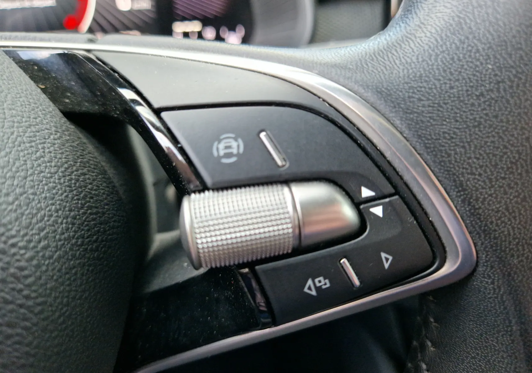 Gros plan sur la molette et les boutons de commande du volant du Skoda Kamiq gris graphite 2024.