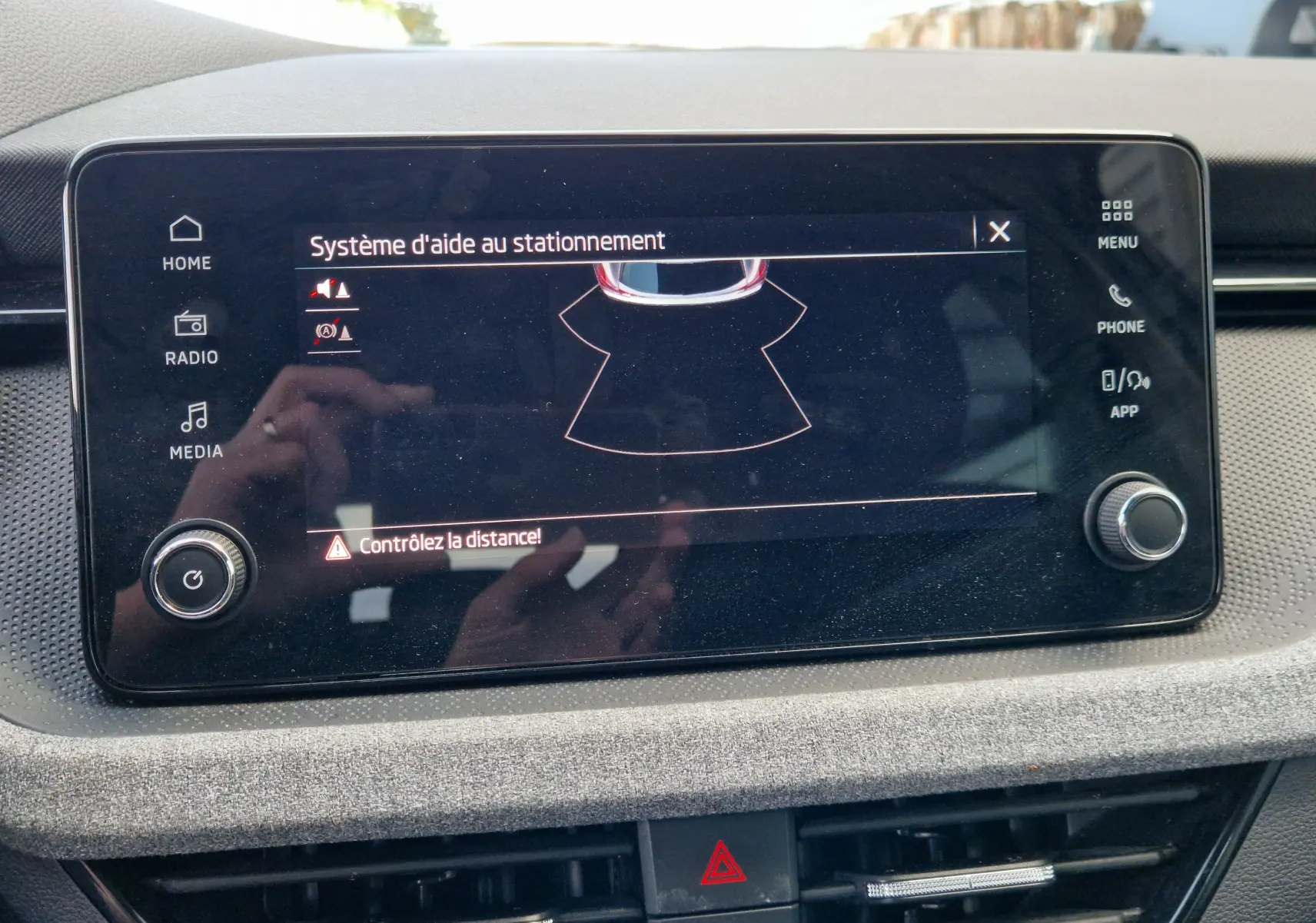 Écran tactile central du Skoda Kamiq 2024 affichant le système d'aide au stationnement avec alertes de distance.