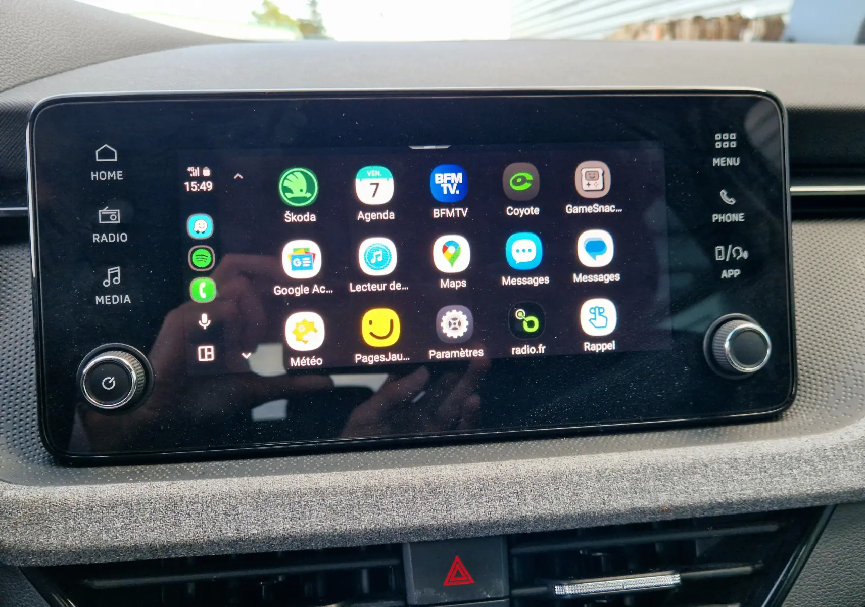 Écran tactile central du Skoda Kamiq 2024 affichant les applications connectées, entouré de commandes et finition tissu gris-noir.