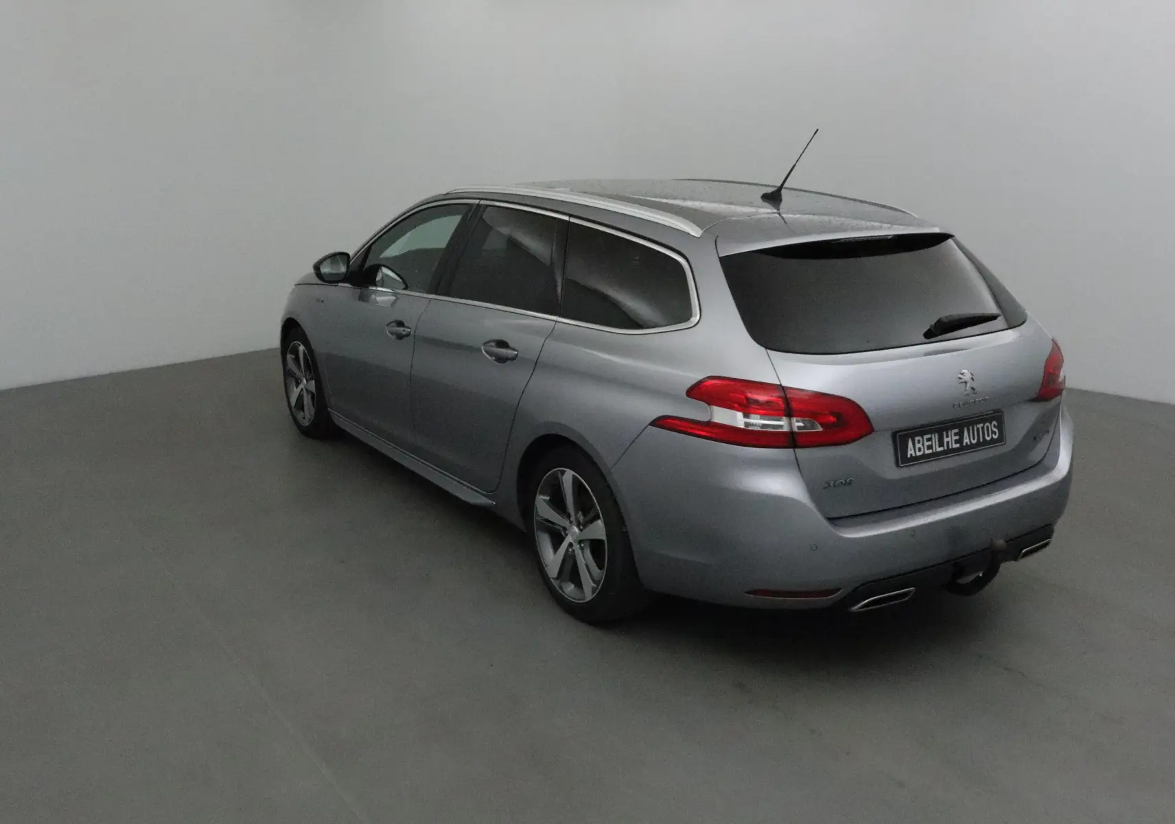 Peugeot 308 SW gris Artense vue 3/4 arrière droit, vitres teintées et jantes alliage 17 pouces visibles.