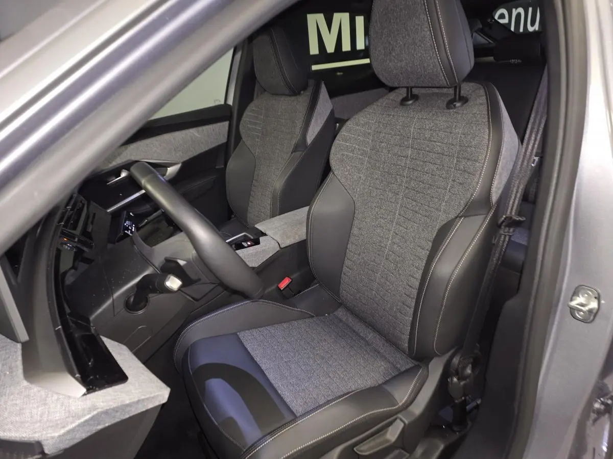 Vue intérieure côté conducteur du Peugeot 3008 gris, sièges tissu gris et cuir noir avec surpiqûres quartz.