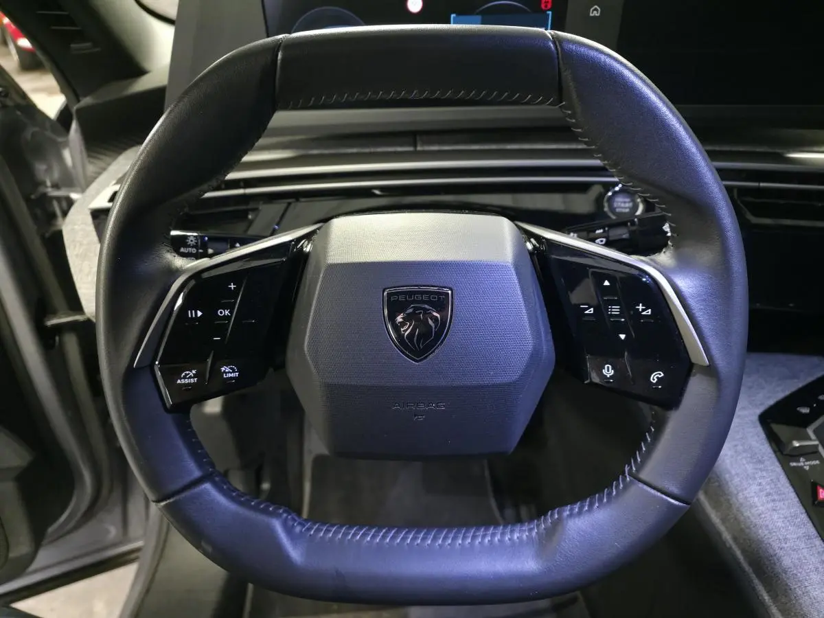 Volant noir en cuir du Peugeot 3008 2025, vue frontale centrée avec logo lion et commandes intégrées.