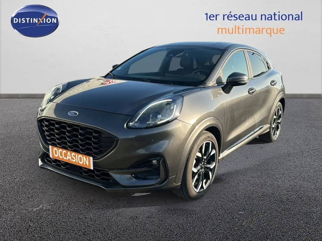 Ford Puma gris foncé vue 3/4 avant droit avec jantes alliage noires et calandre imposante.