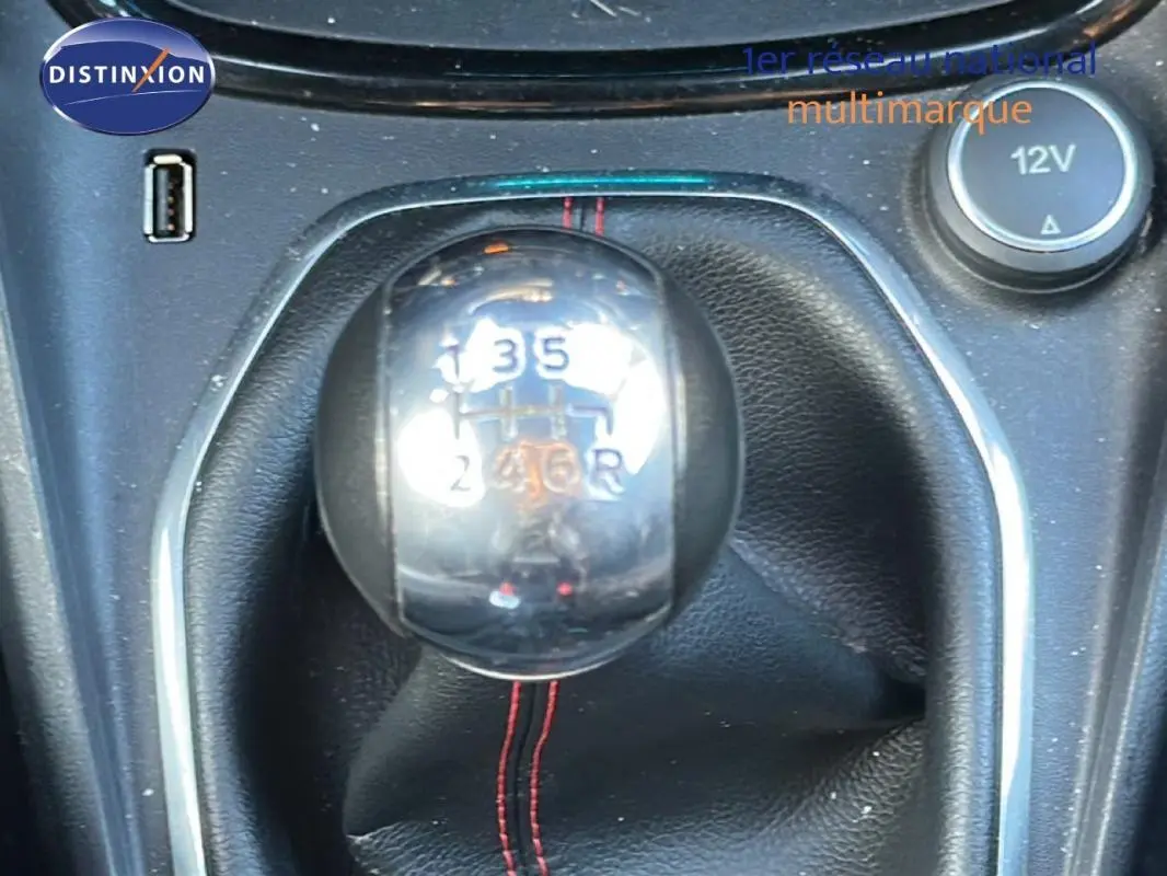 Gros plan sur le levier de vitesses manuel noir avec surpiqûres rouges dans une Ford Puma gris foncé de 2020.