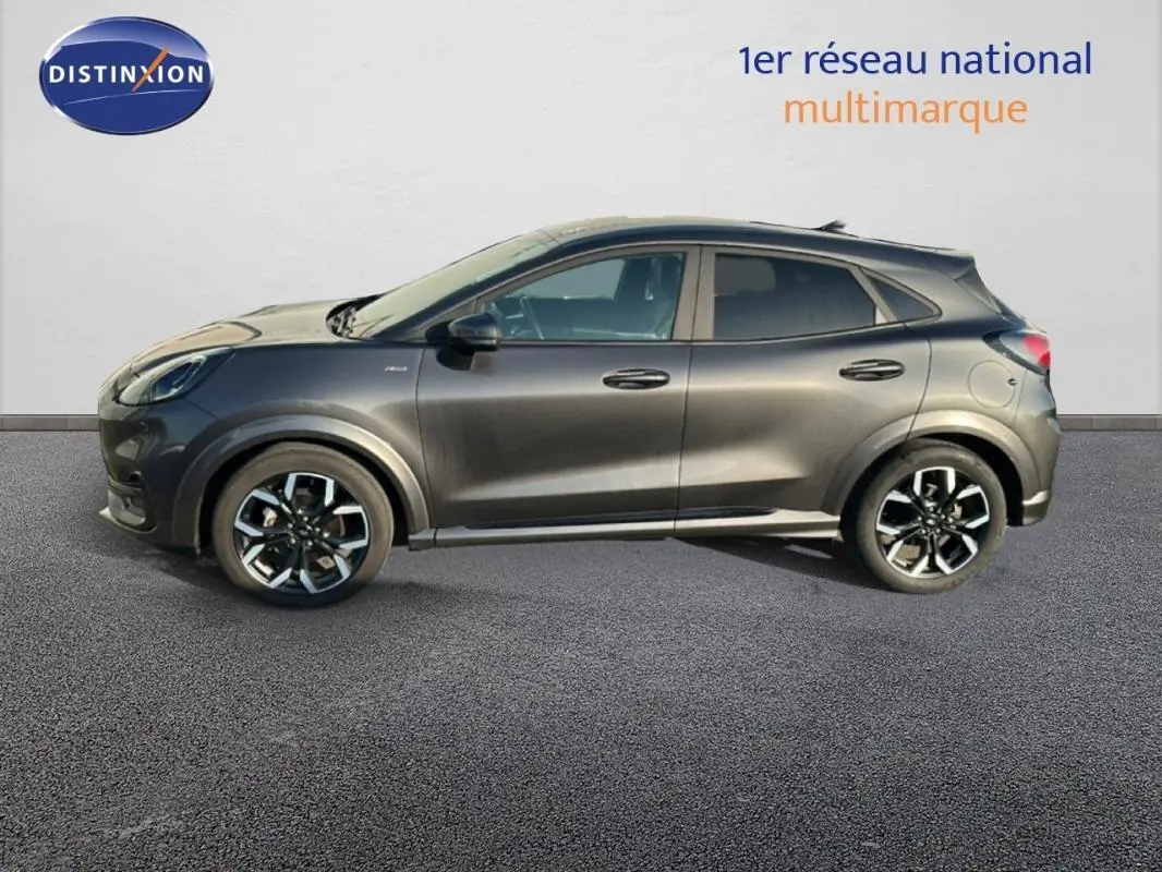 Vue de profil côté gauche d’un Ford Puma gris foncé avec jantes alliage 18 pouces sur fond neutre.