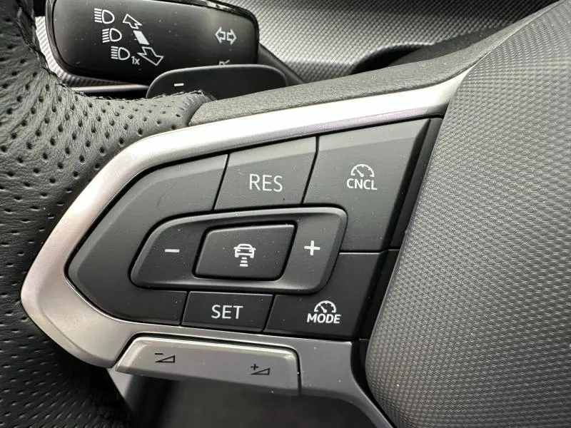 Gros plan sur les commandes de régulateur de vitesse au volant perforé d’une Volkswagen Golf 2.0 TDI 150ch R-Line gris 2026.
