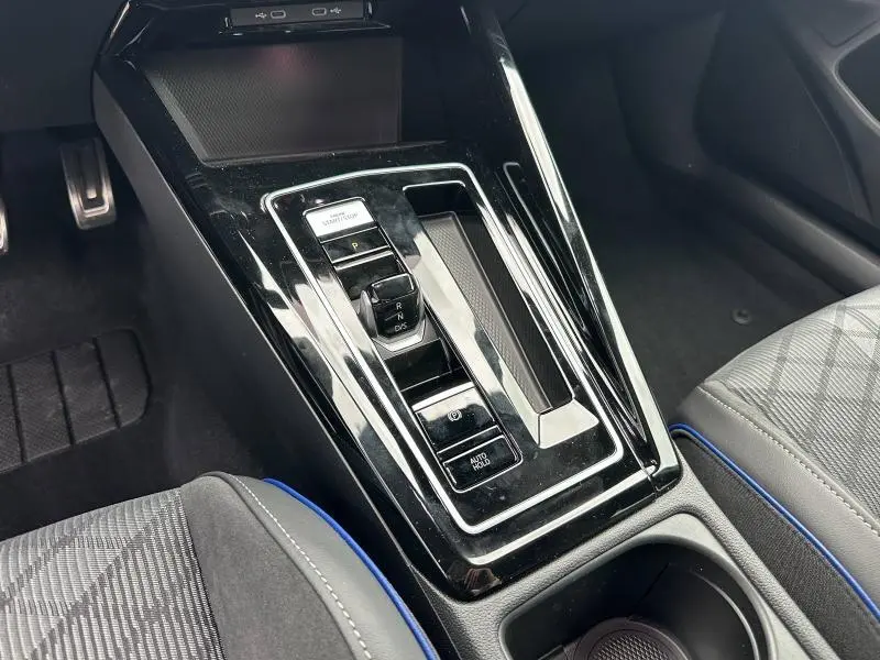 Vue rapprochée de la console centrale noire brillante avec levier de vitesse électronique dans une Volkswagen Golf gris 2.0 TDI 2026.