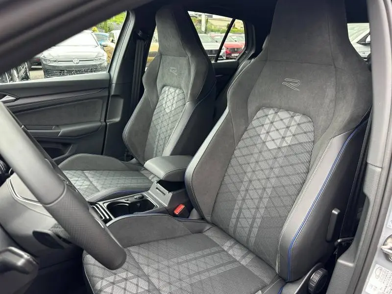 Vue intérieure rapprochée des sièges avant gris avec surpiqûres bleues du Volkswagen Golf 2.0 TDI R-Line 2026.