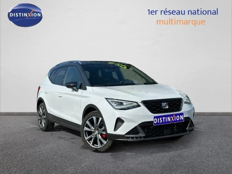 SEAT Arona 1.0 TSI 115ch FR blanc Candy avec toit noir Minuit, vue 3/4 avant mettant en valeur ses jantes et calandre.