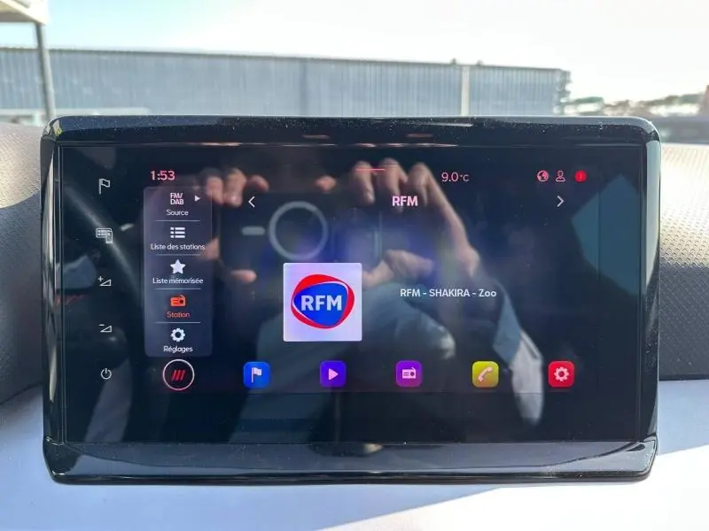 Écran tactile central du tableau de bord du SEAT Arona 2025, affichant la radio RFM avec interface moderne.