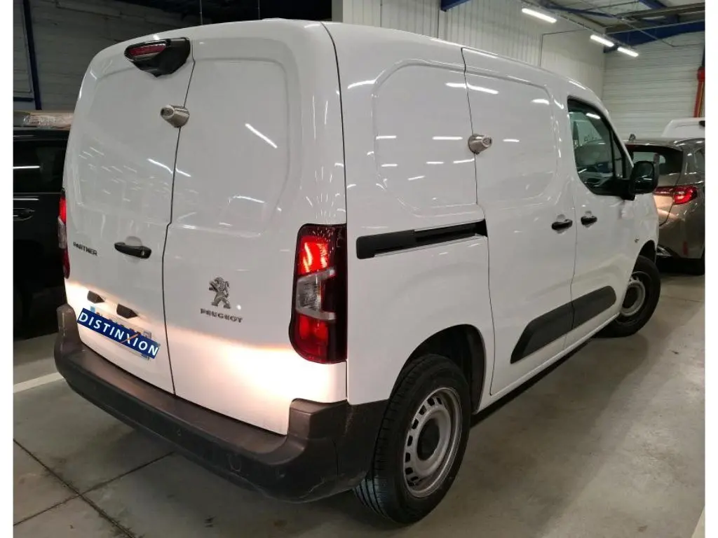 Vue 3/4 arrière droite d'un Peugeot Partner Fourgon blanc 2022 avec portes arrière battantes et protections noires.