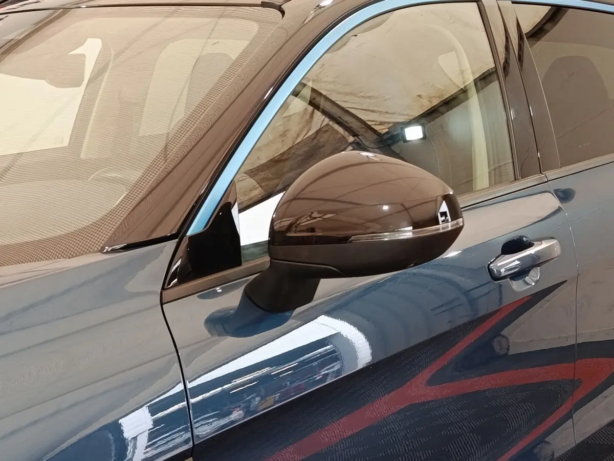 Vue rapprochée du rétroviseur droit et de la portière bleu métallisé du SUV Link & Co 01 hybride rechargeable 2023.