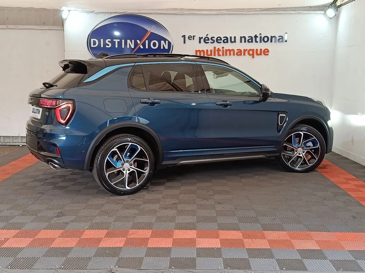 Vue de profil côté gauche d'un SUV Link & Co 01 hybride rechargeable bleu avec jantes bicolores et toit noir.