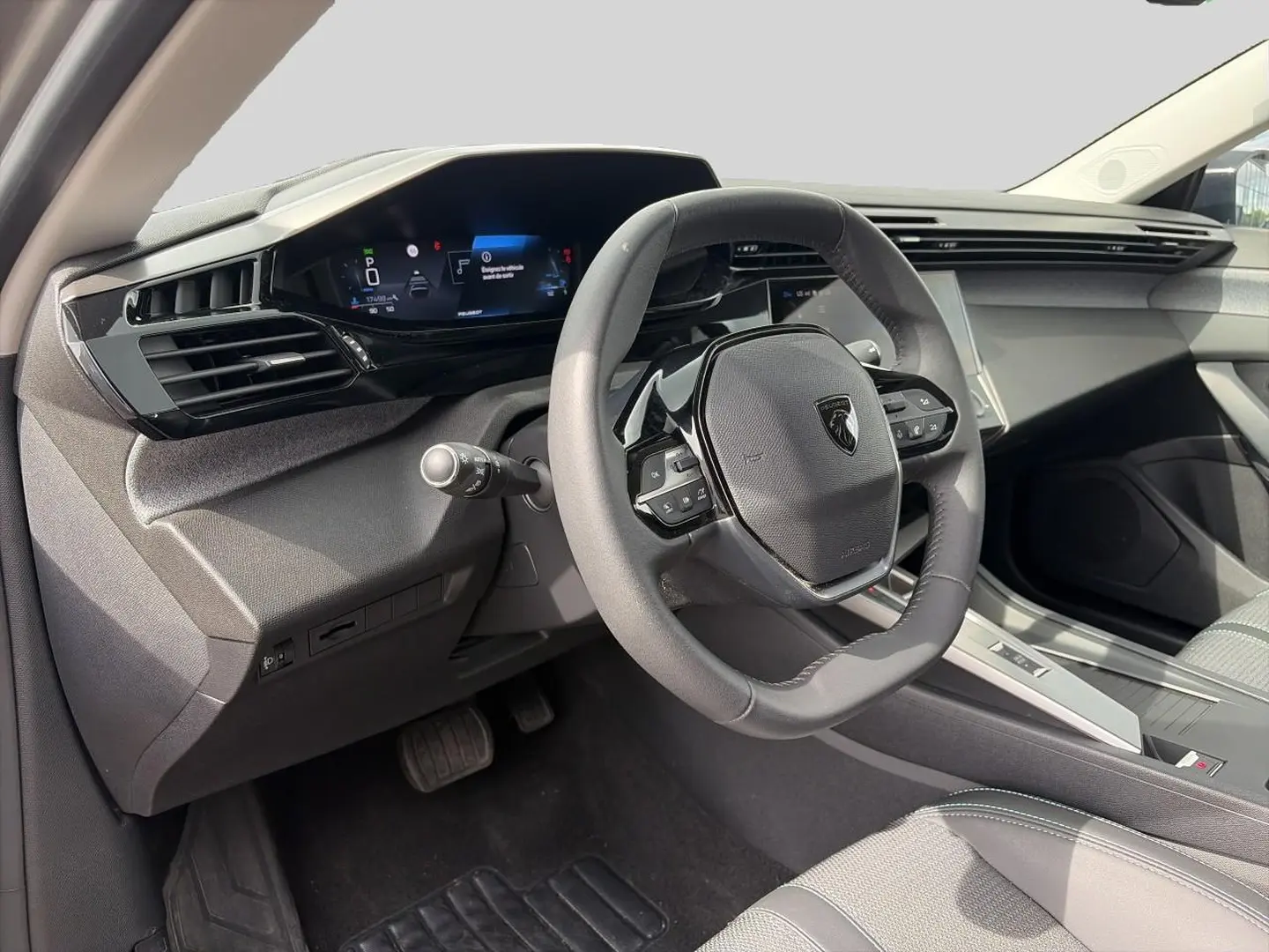 Intérieur de la Peugeot 308 2025, vue côté conducteur sur le volant multifonction et tableau de bord numérique.