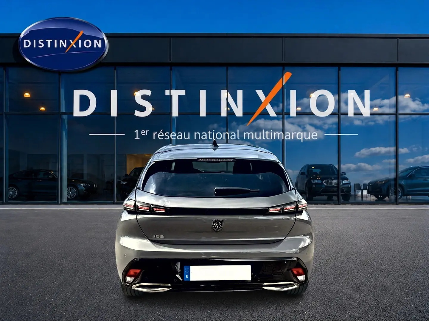 Vue arrière d'une Peugeot 308 gris selenium 2025, avec feux arrière LED et double sortie d'échappement chromée.