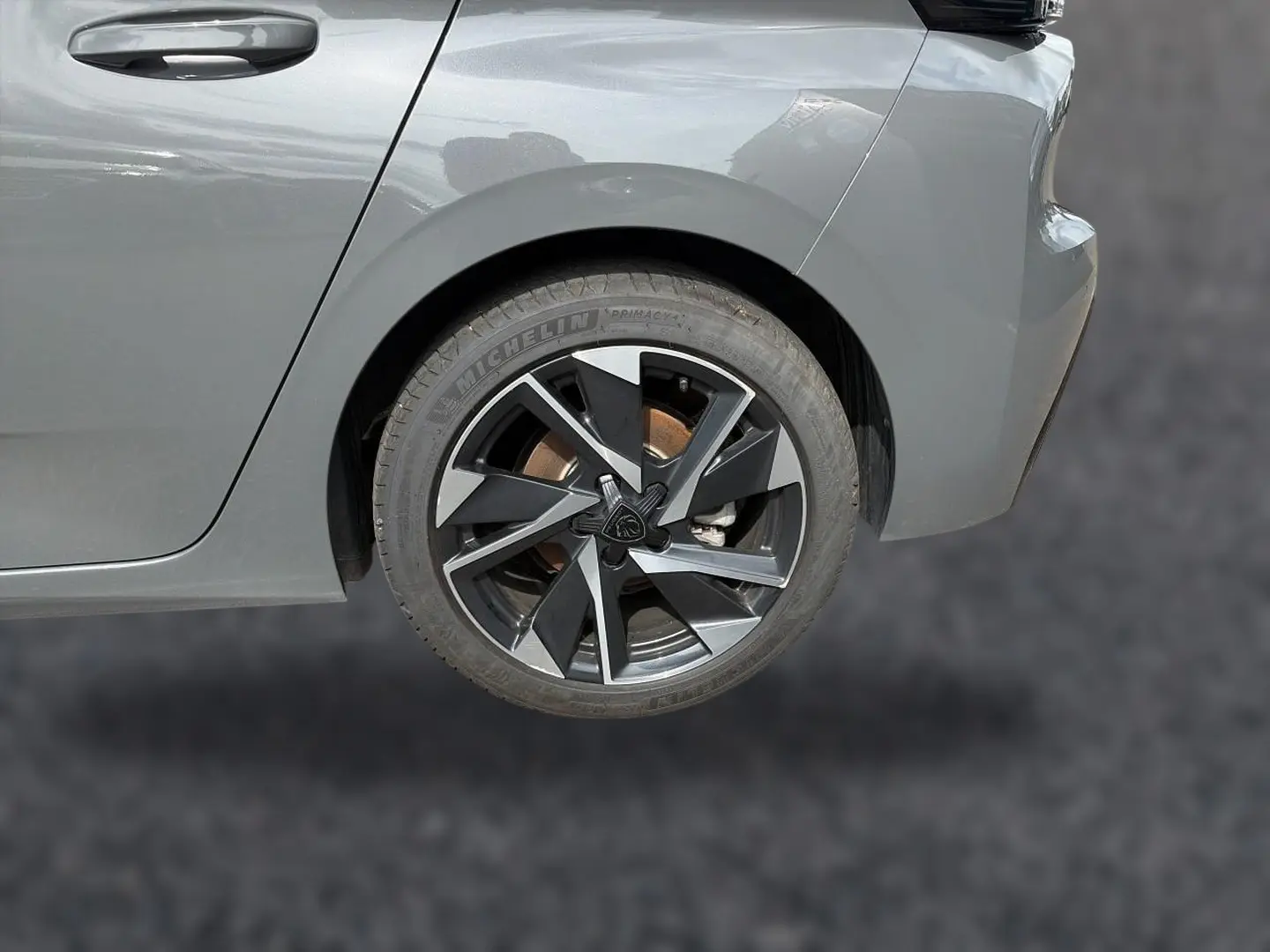 Gros plan sur la roue arrière droite d'une Peugeot 308 gris selenium avec jante alu au design moderne.