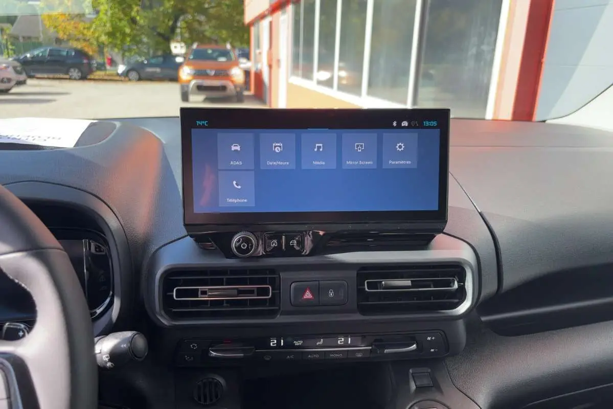 Vue intérieure du tableau de bord du Citroën Berlingo 2026 noir, avec écran tactile central et commandes de climatisation.