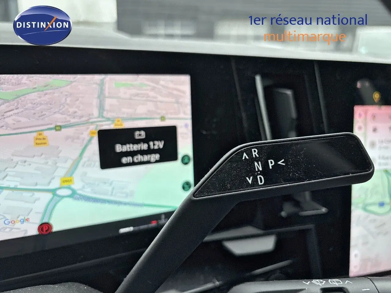 Le levier de boîte automatique noir de la Renault Austral 2023, avec l'écran de navigation en arrière-plan.