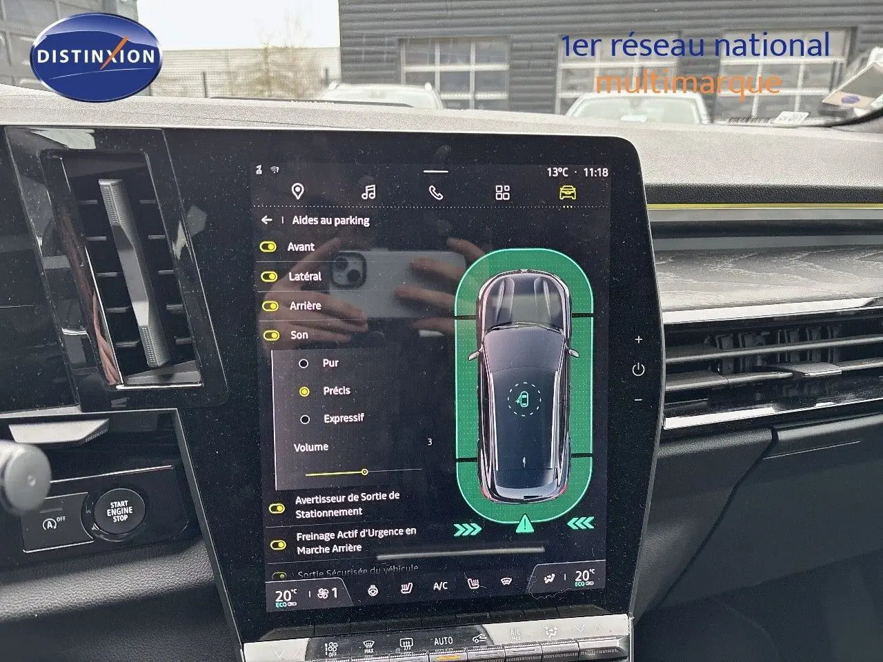 Vue intérieure centrée sur l'écran tactile du tableau de bord du Renault Austral noir étoile métal, affichant l'aide au parking.
