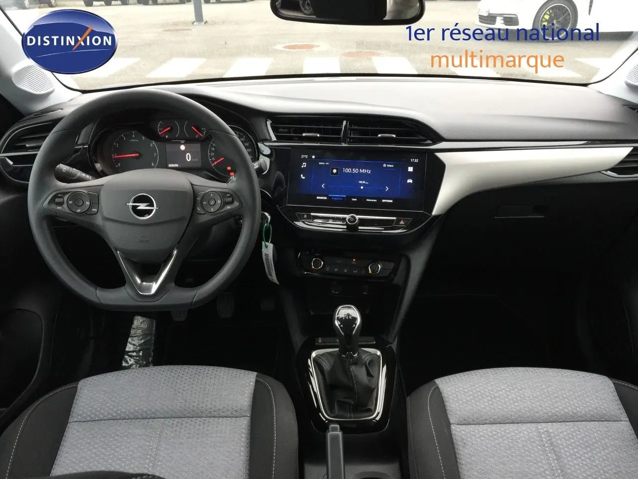 Vue intérieure avant de l'Opel Corsa 2025 avec tableau de bord moderne, volant multifonction et levier de vitesse manuel.