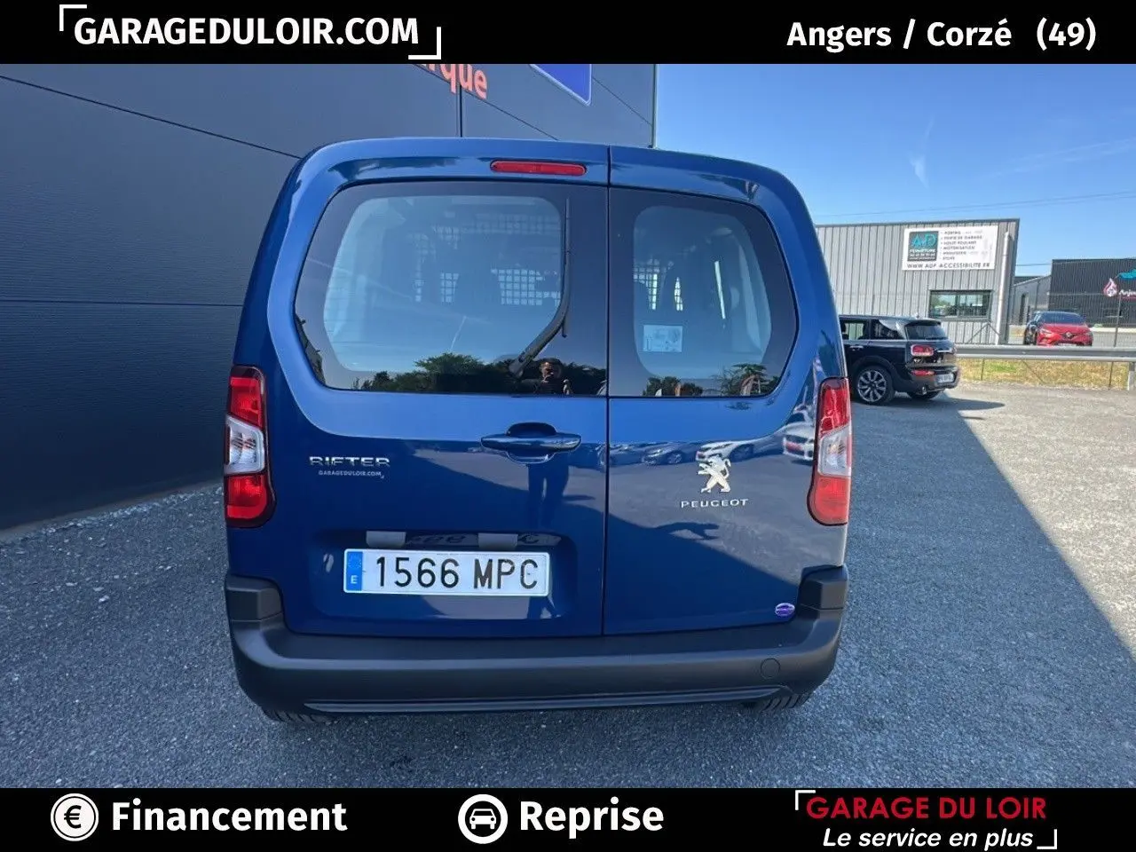 Vue arrière d'un Peugeot Rifter bleu 2024 avec portes battantes et logo visible sur un parking extérieur.