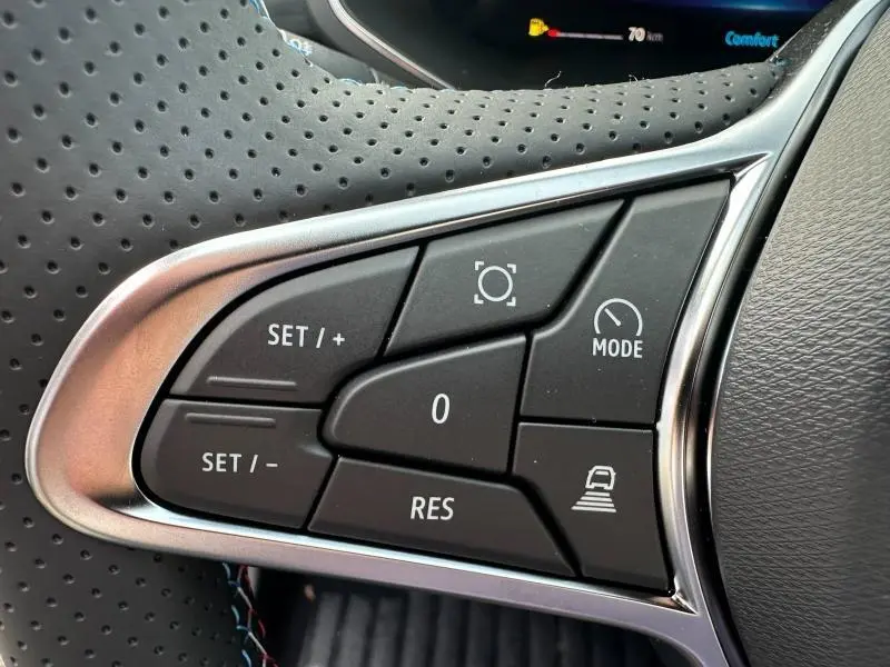 Gros plan sur les commandes au volant du Renault Captur 2026, finition Esprit Alpine, avec cuir perforé noir et surpiqûres tricolores.