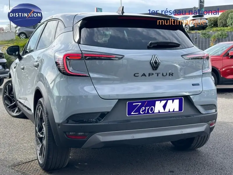 Vue 3/4 arrière d'un Renault Captur 2026 gris Rafale avec toit noir étoilé et feux arrière LED distinctifs.