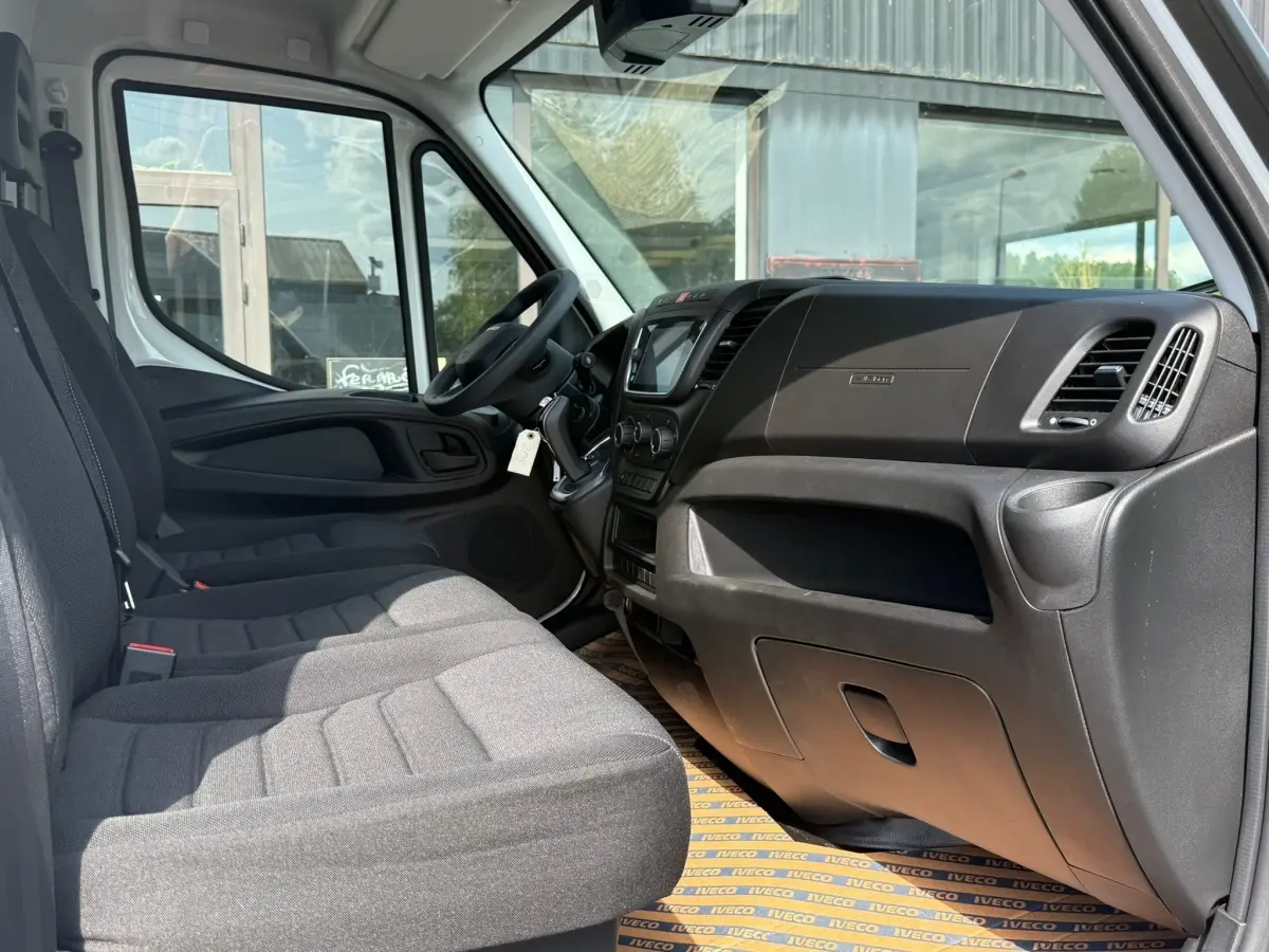 Vue intérieure côté passager de l'Iveco Daily blanc 35S18 2026, montrant tableau de bord et sièges gris.