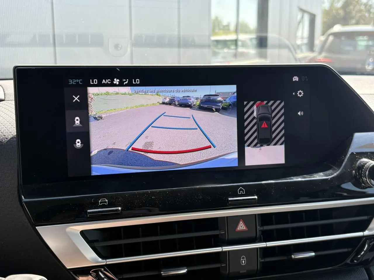 Écran tactile intérieur montrant la caméra de recul avec guidage dynamique sur un Citroën C4 blanc Okénite.