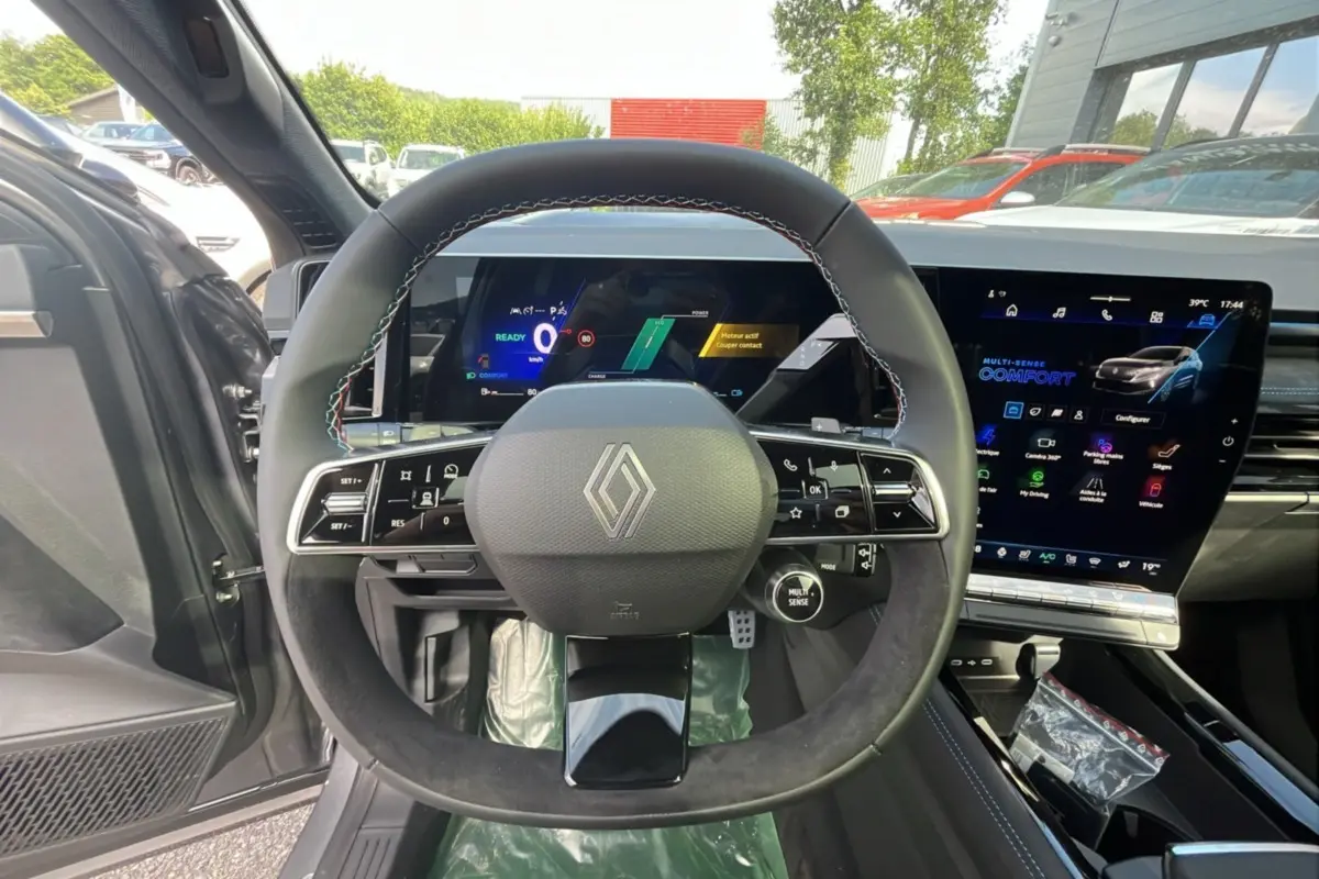 Vue intérieure centrée sur le volant cuir multifonctions du Renault Austral 200 Esprit Alpine, avec écran tactile et tableau de bord numérique.