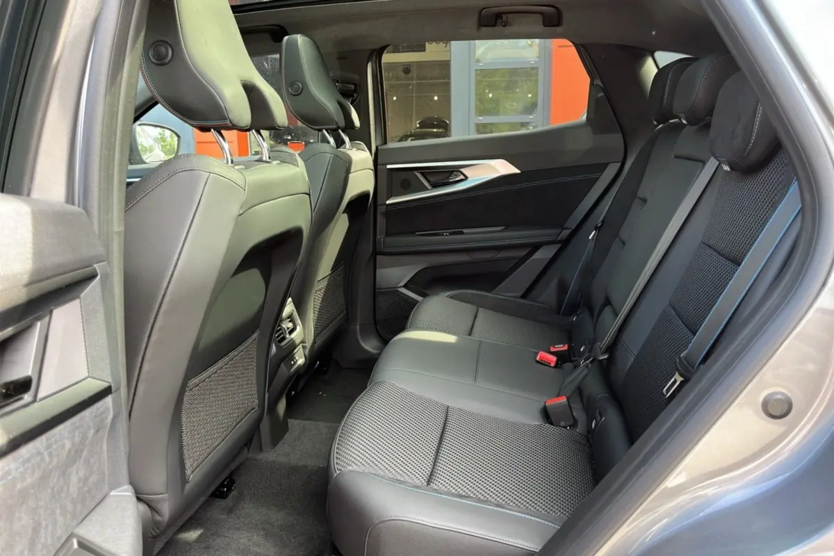 Vue intérieure arrière droite du Renault Austral 200 Esprit Alpine, montrant les sièges semi-alcantara noirs et les finitions modernes.