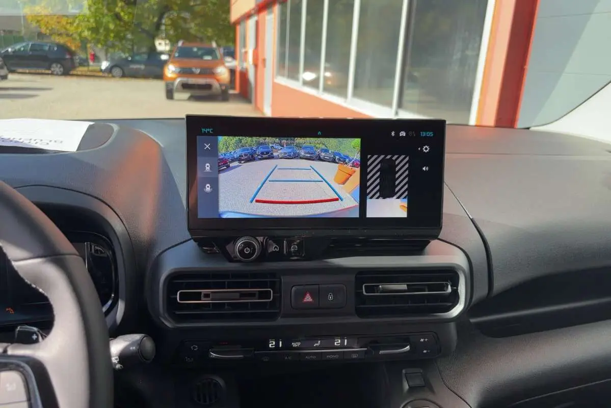 Vue intérieure du tableau de bord du Citroën Berlingo noir perla nera, écran tactile affichant la caméra de recul en plein jour.