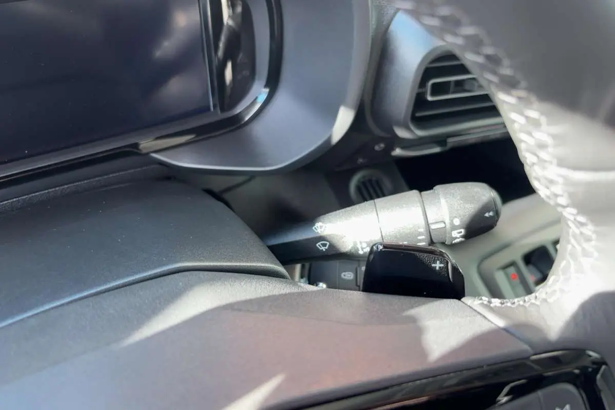 Gros plan sur le volant cuir et la commande de clignotant du Citroën Berlingo 2026, intérieur noir.